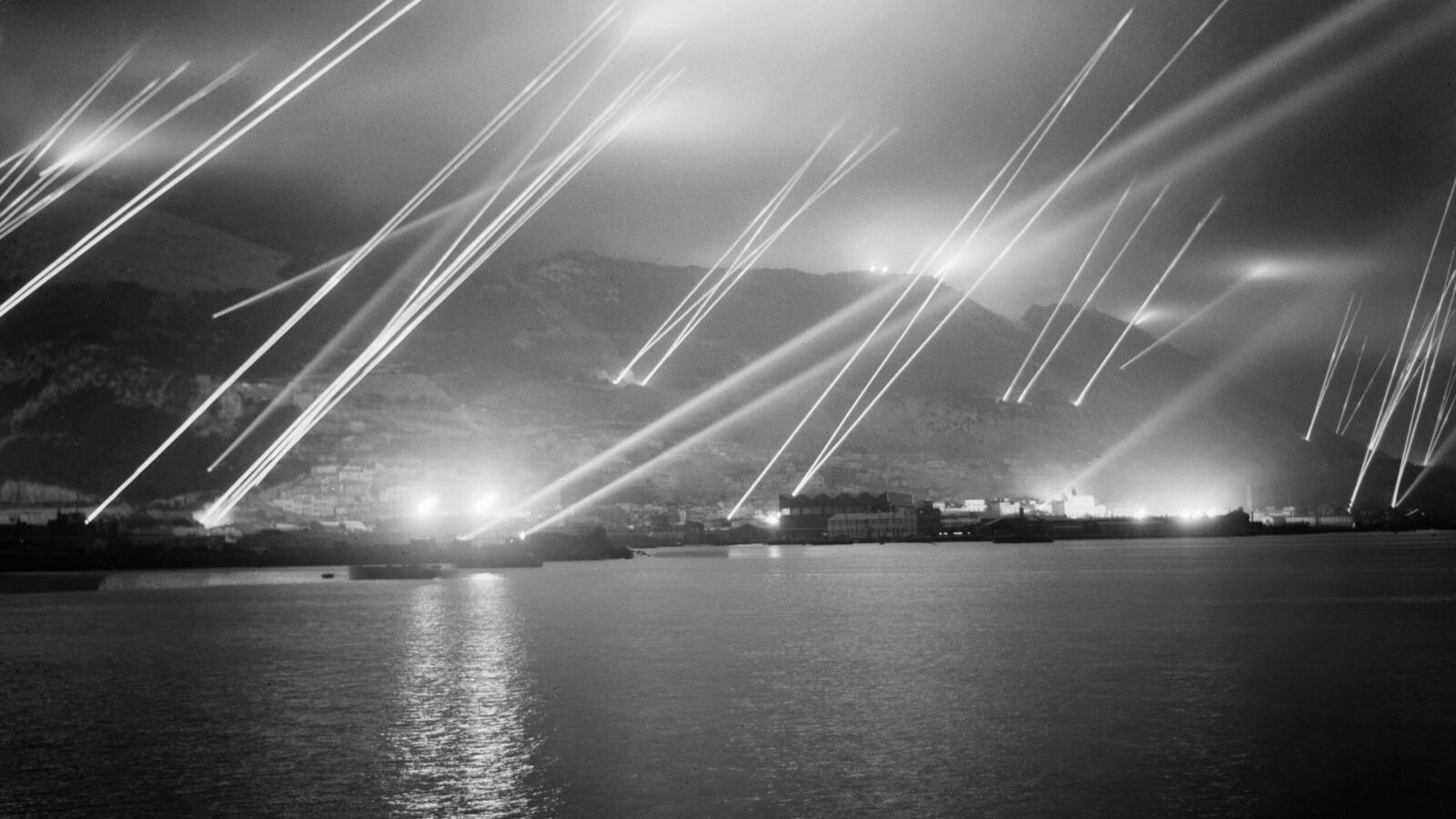 Anti-aircraft searchlights piercing the night sky over the Rock of Gibraltar during an air-raid practice, November 20, 1942
