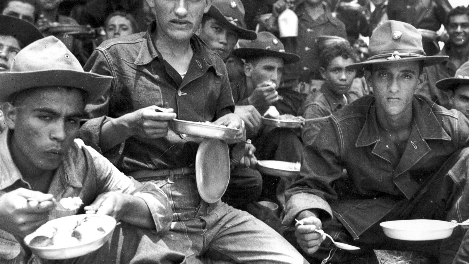 Soldiers of the Puerto Rican 65th Infantry Regiment (Borinqueneers) resting after a full day of field maneuvers at Salinas, Puerto Rico, August 1941