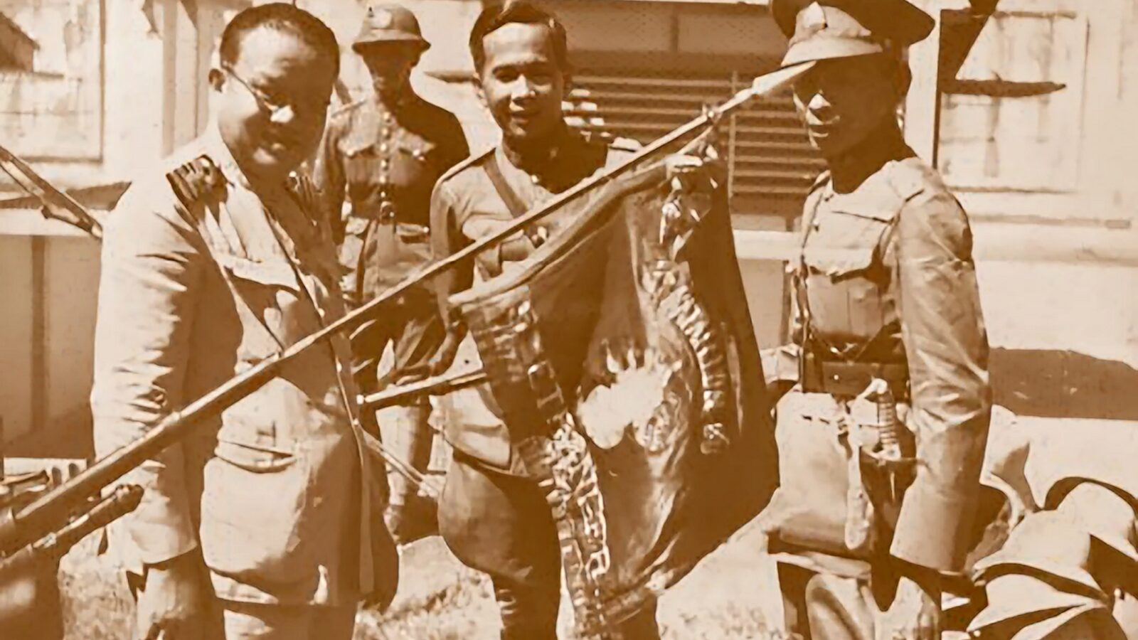 Thai Prime Minister Plaek Phibunsongkhram and officers inspecting a captured French Foreign Legion flag after the Battle of Phum Preav, January 1941