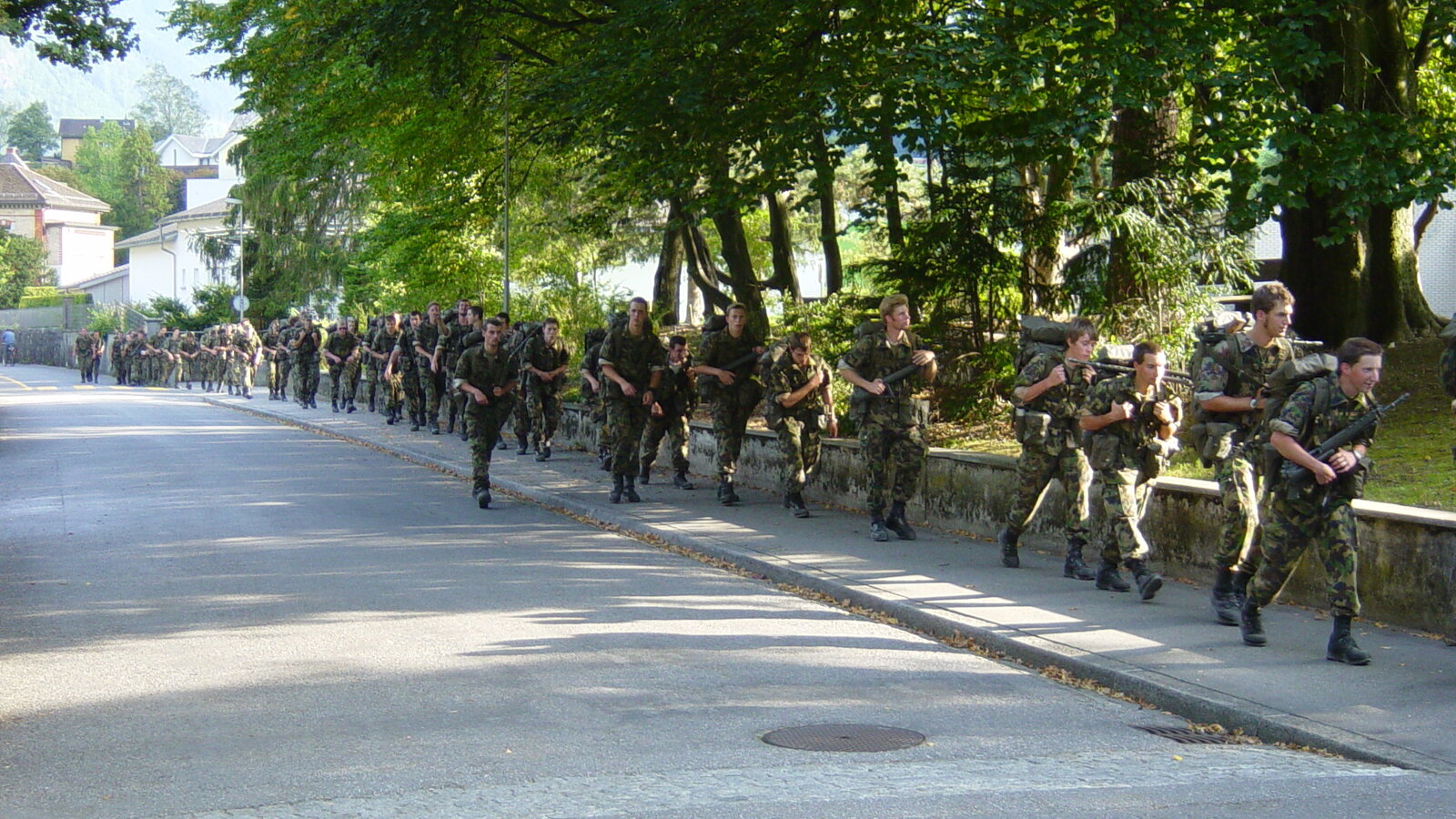 Swiss Army troops marching in formation - the militia structure that mobilizes from a small active core to roughly 100,000 within days